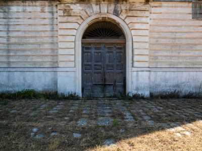 A dominare la facciata � l�ampio portone in legno iscritto in un arco in pietra ai cui lati sono presenti due finestre entrambe murate